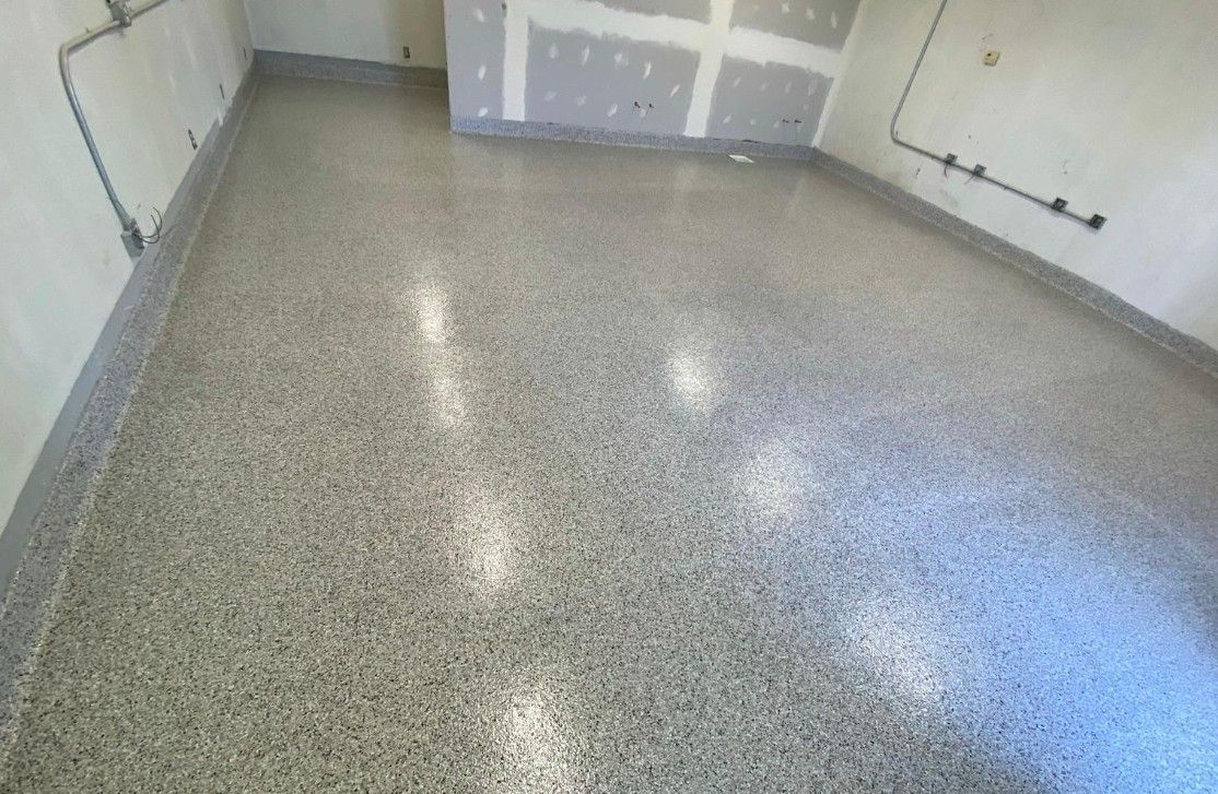 Professionally installed gray flake floor coating in a clean garage, showing a durable finished surface that adds long-term value through improved appearance, everyday function, and a more polished overall space.