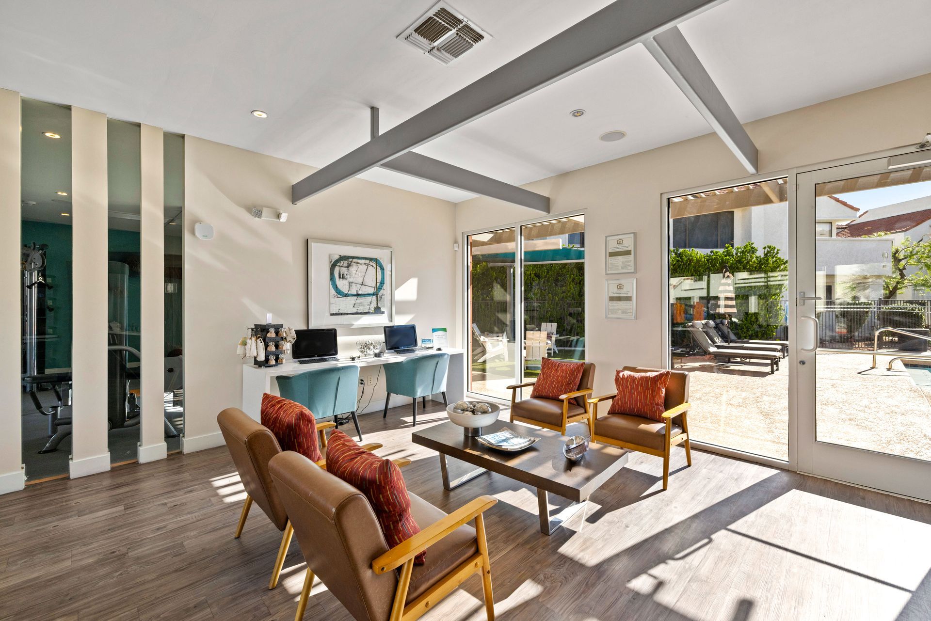 Lounge area with seating, desks, and outdoor access. Features include wood flooring and accent wall. Talavera Apartments delivers elevated apartments in Tempe AZ—take a closer look.