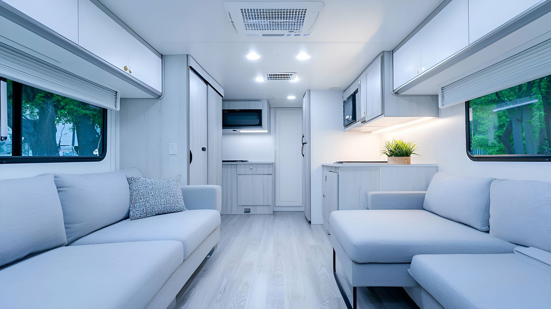 Un salon dans un camping-car avec un canapé et une cuisine.