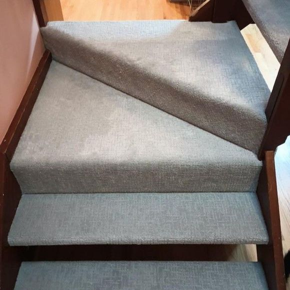 Carpeted stairs with a loose, raised runner forming a trip hazard