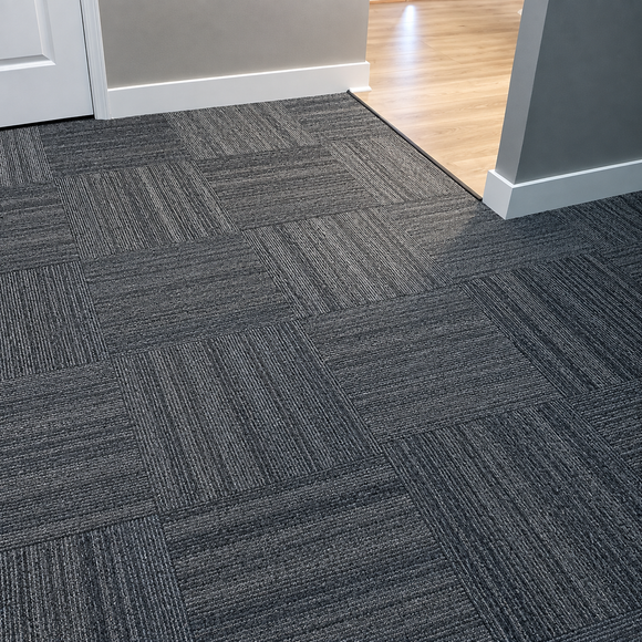 Dark gray carpet leading to a doorway with white walls and light wood flooring beyond
