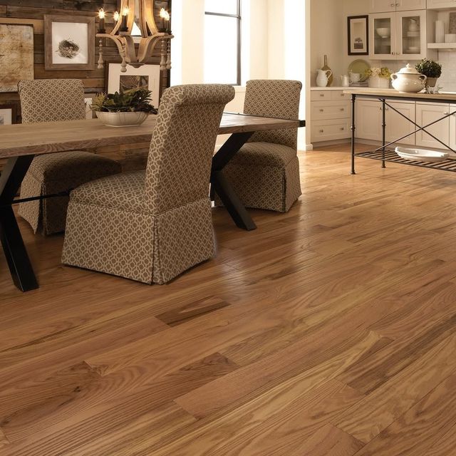Modern dining room with a wooden table, patterned chairs, and warm hardwood flooring