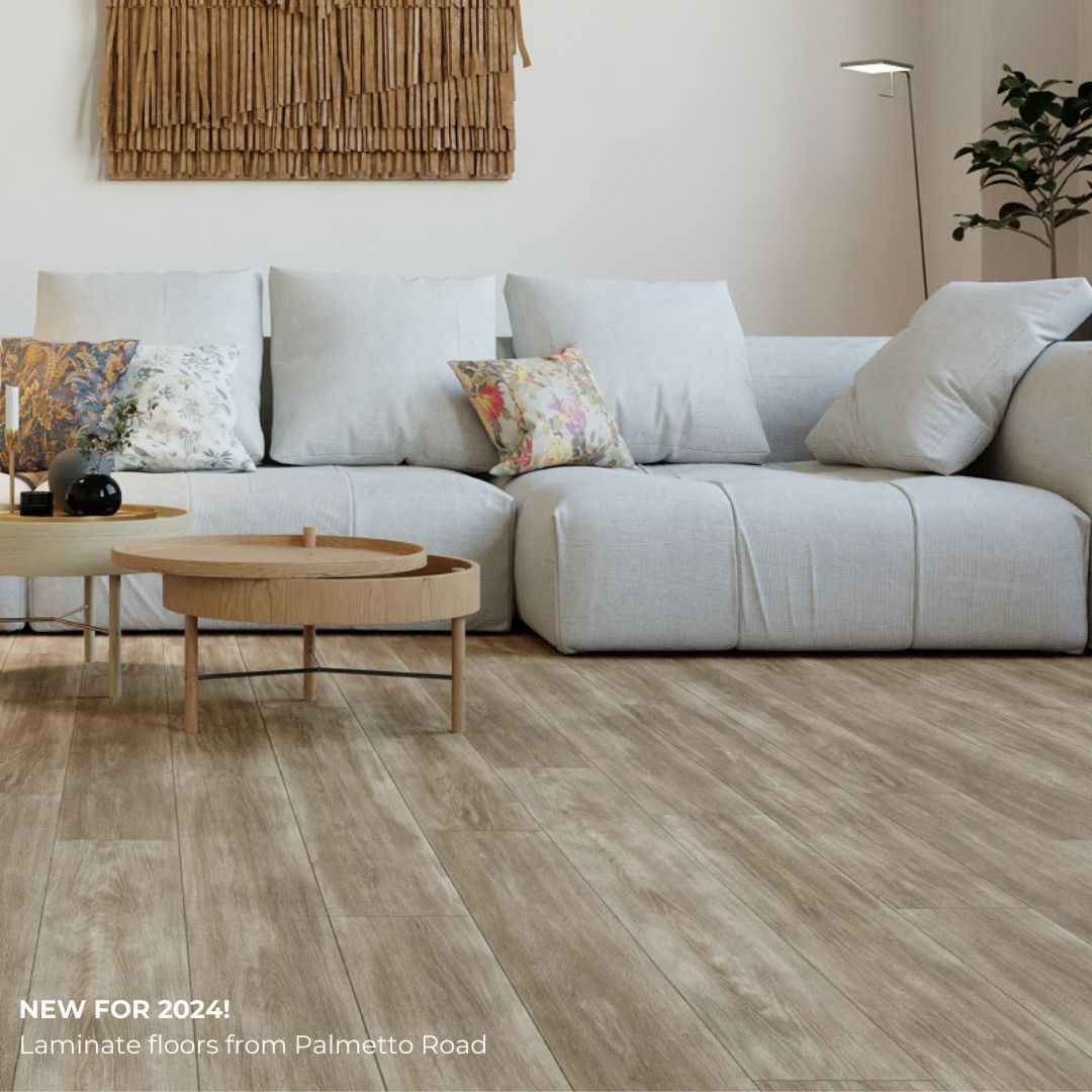 Minimalist living room with beige sofa, woven wall art, round coffee table, and light wood flooring