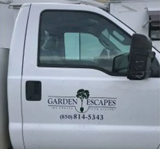 A white truck with garden escapes written on the side