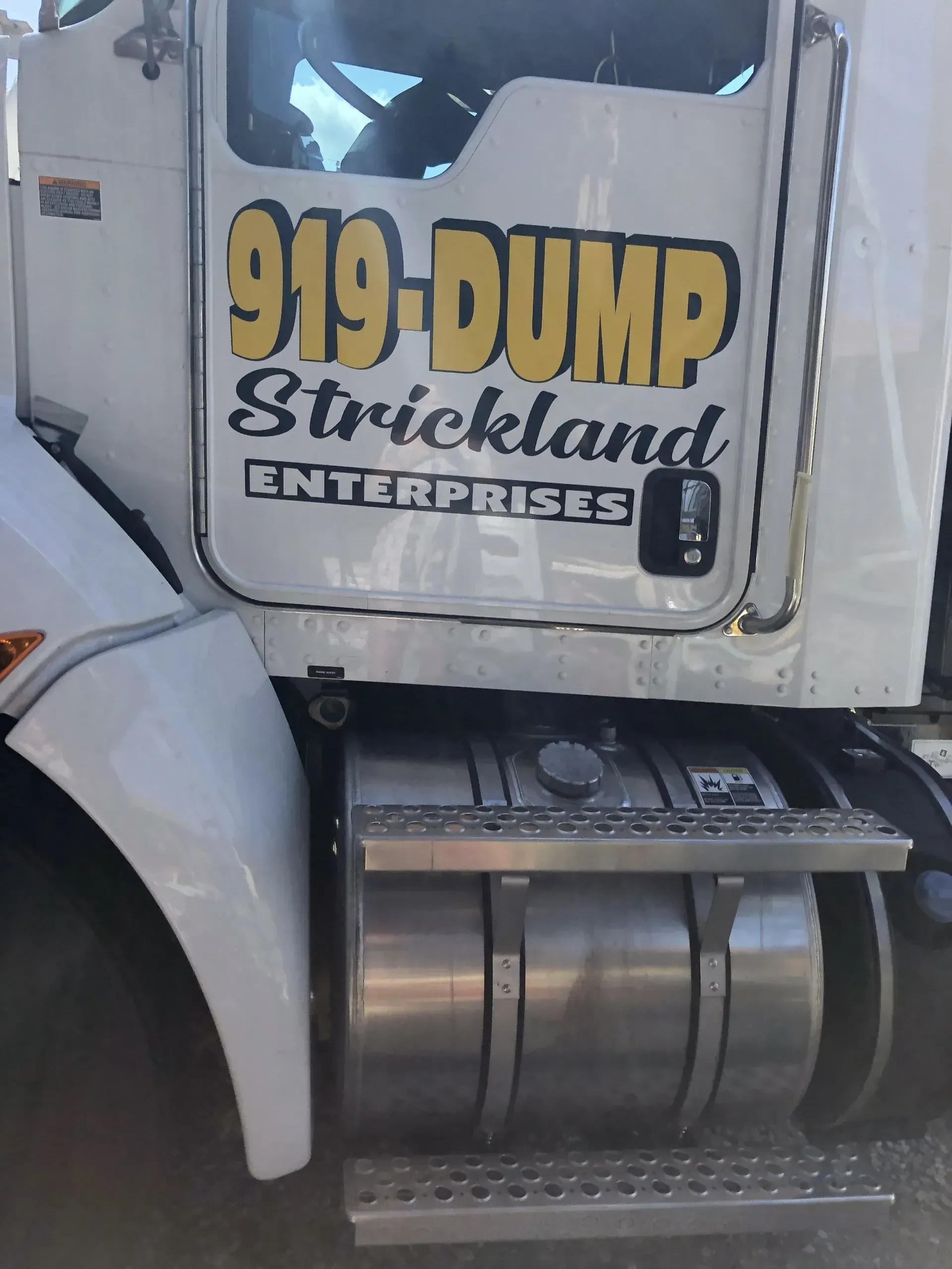 A white dump truck from 919 dump strickland enterprises