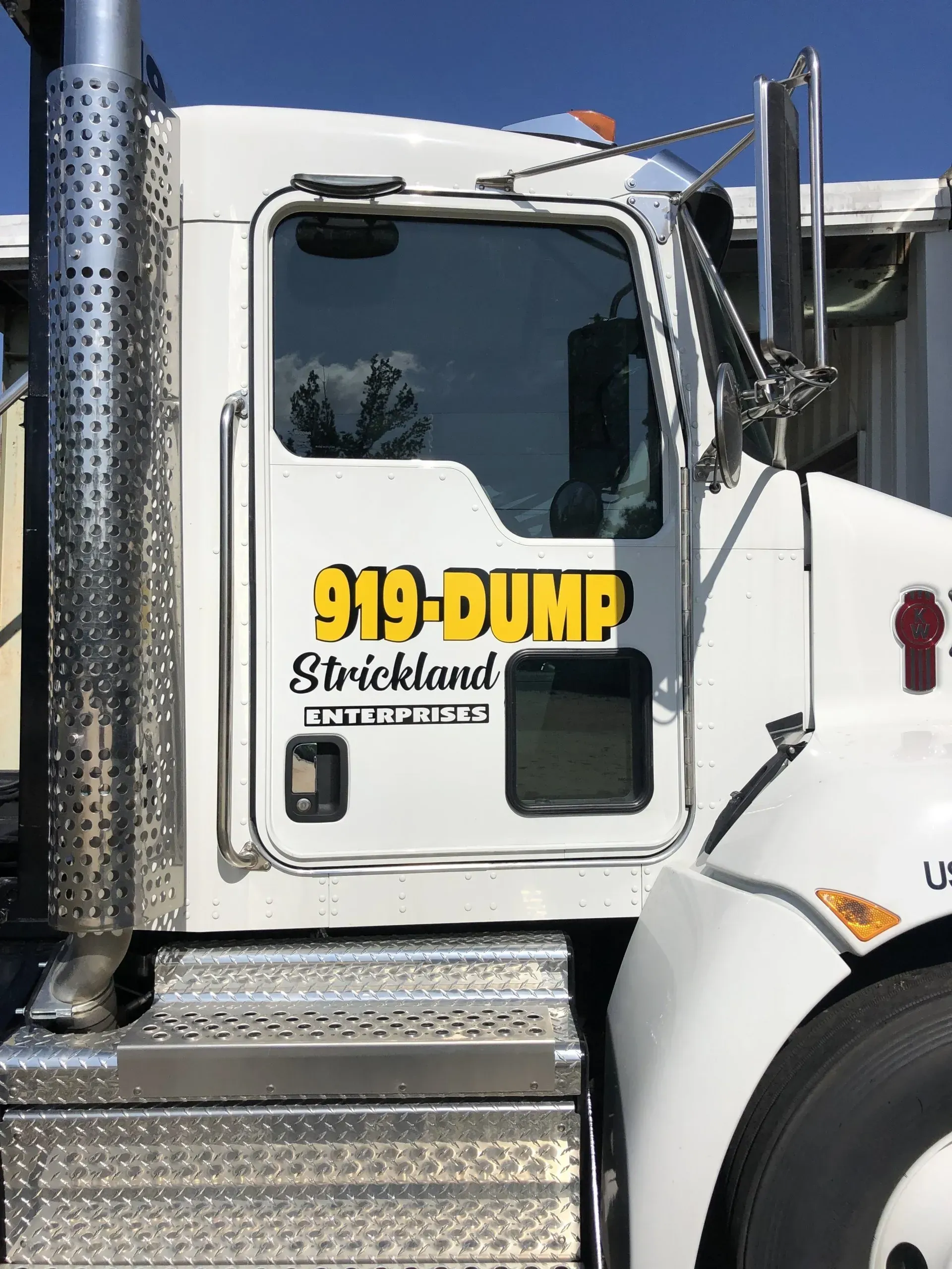 A white dump truck with the number 919 dump on the side