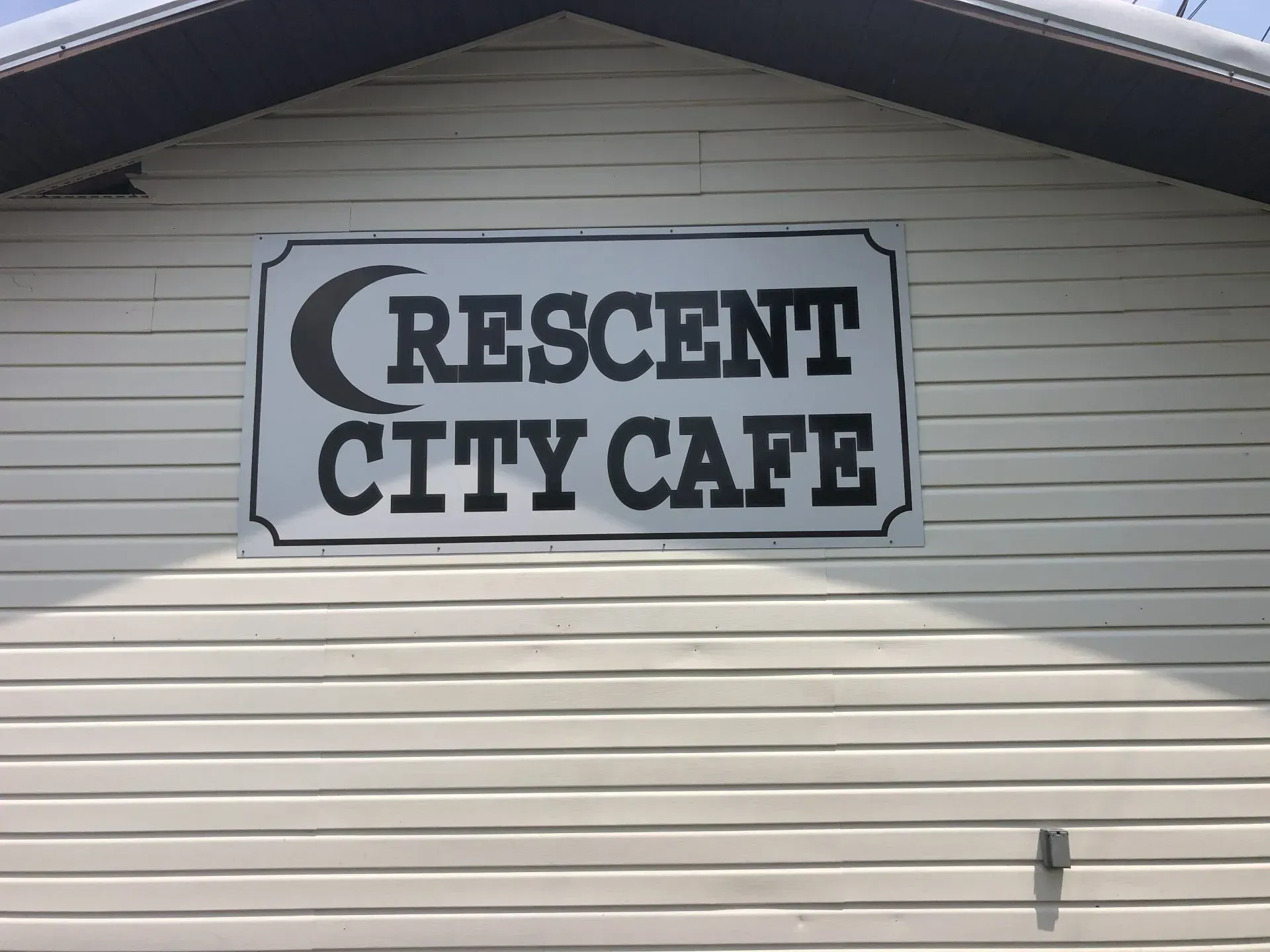 A sign on the side of a building that says crescent city cafe