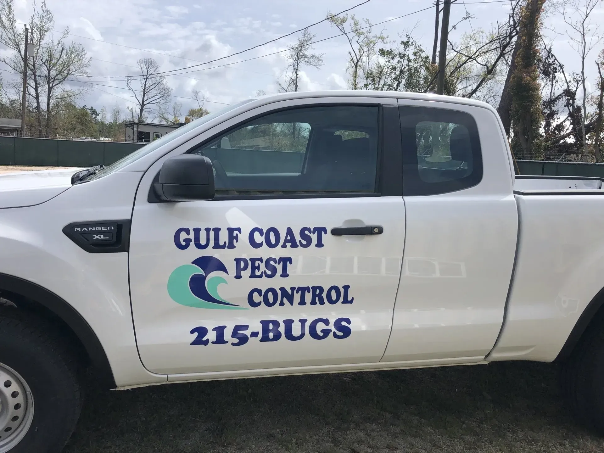 A white truck with gulf coast pest control written on the side