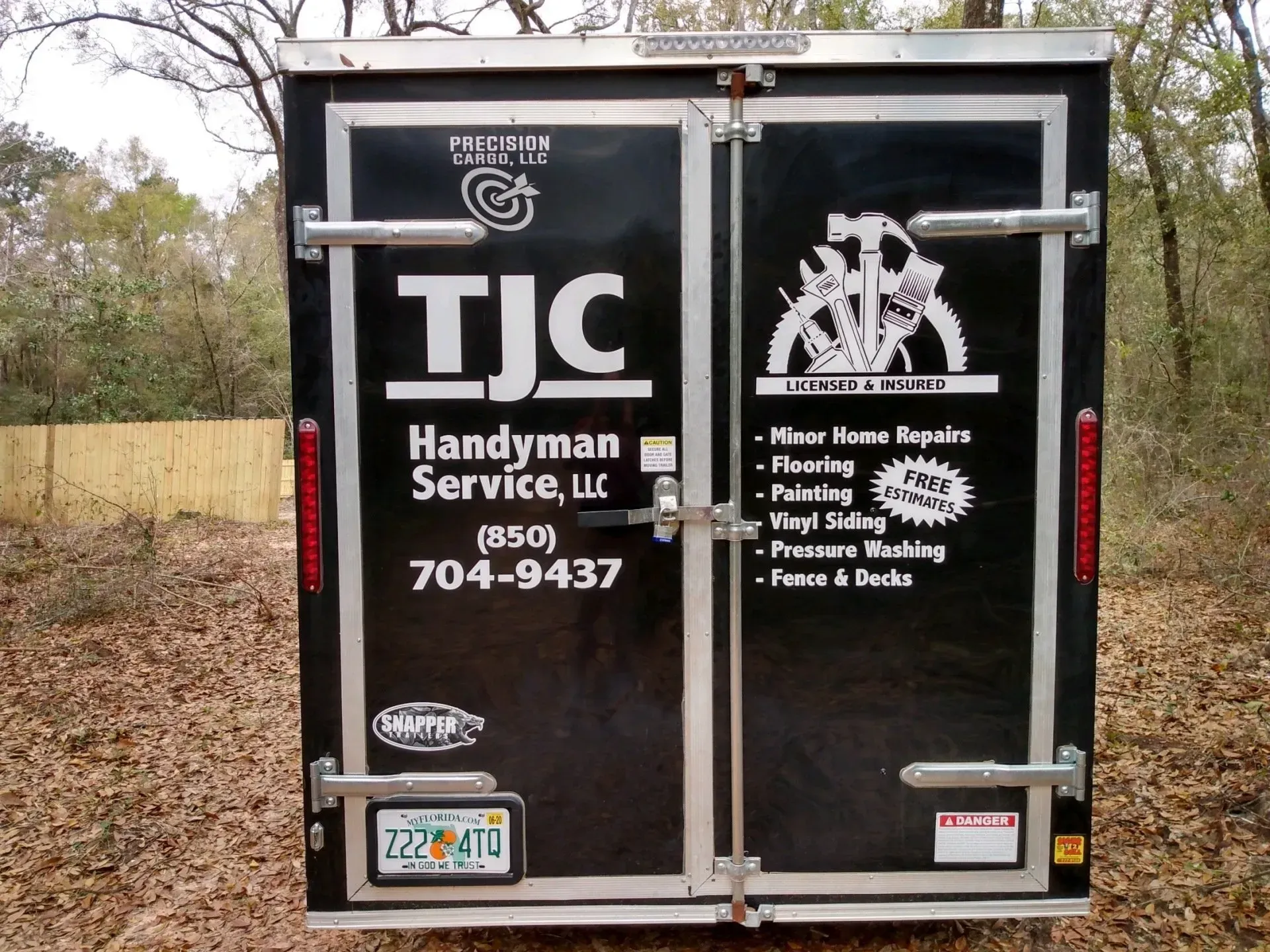 A black trailer with tjc handyman service written on it