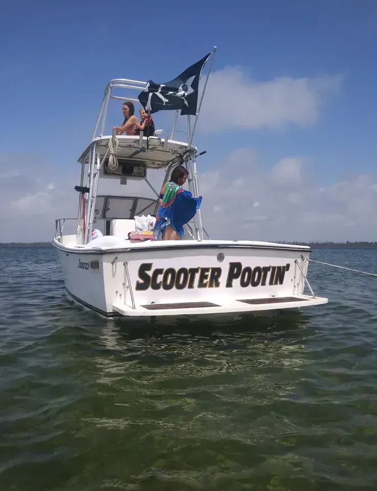 A boat with the name scooter pootin on the back of it