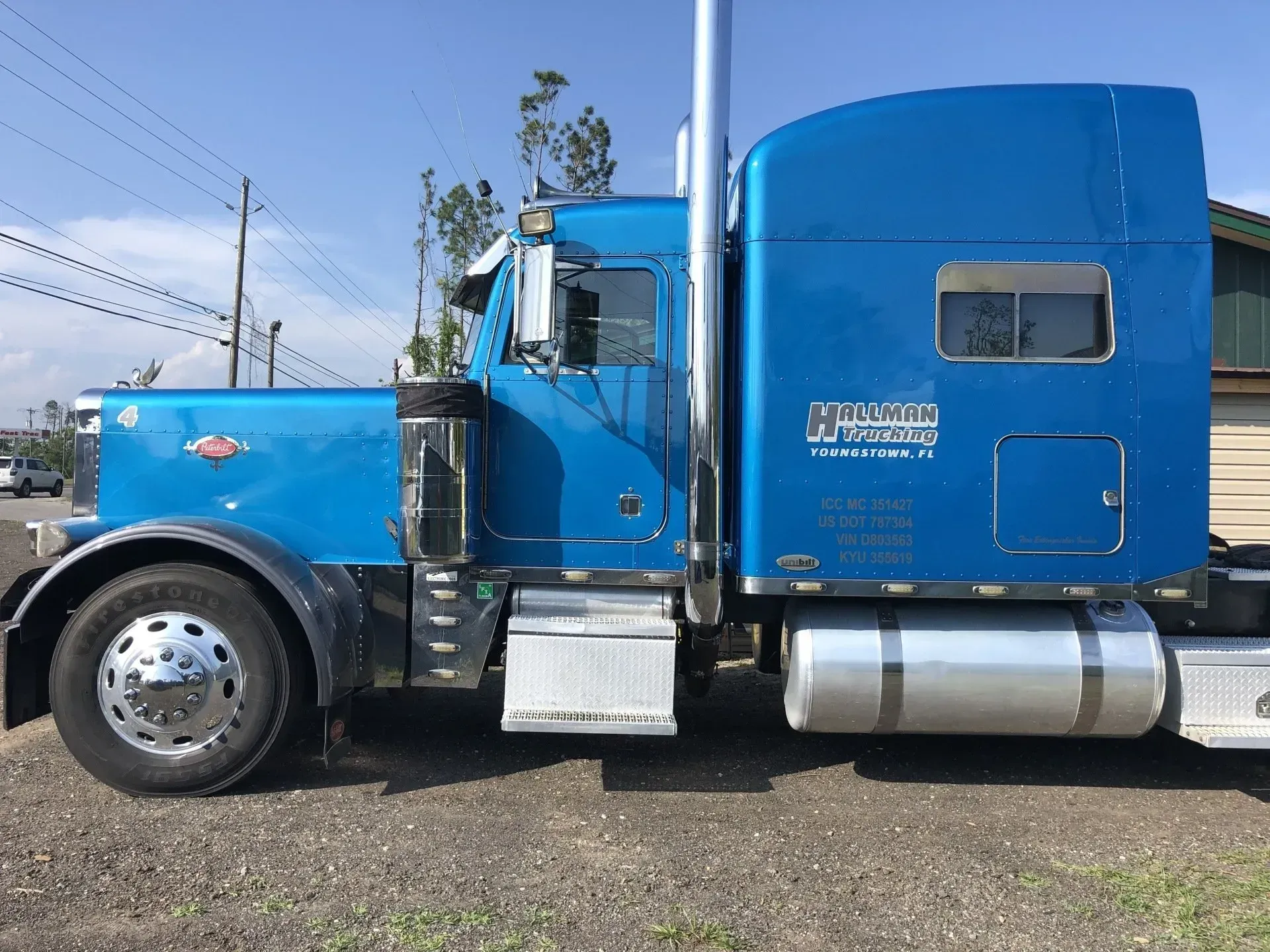 A blue semi truck is parked in front of a house.