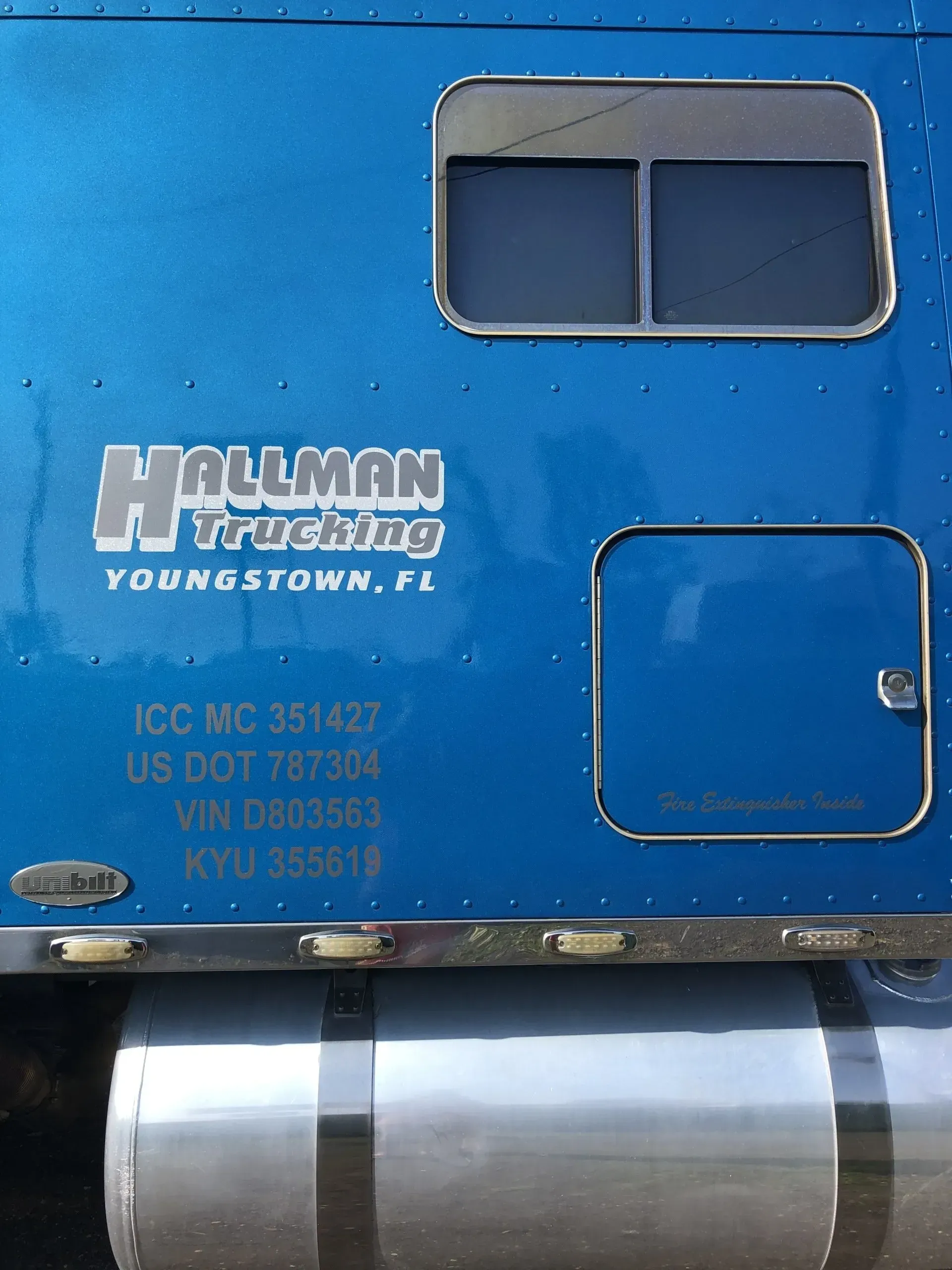 The back of a blue hallman trucking semi truck