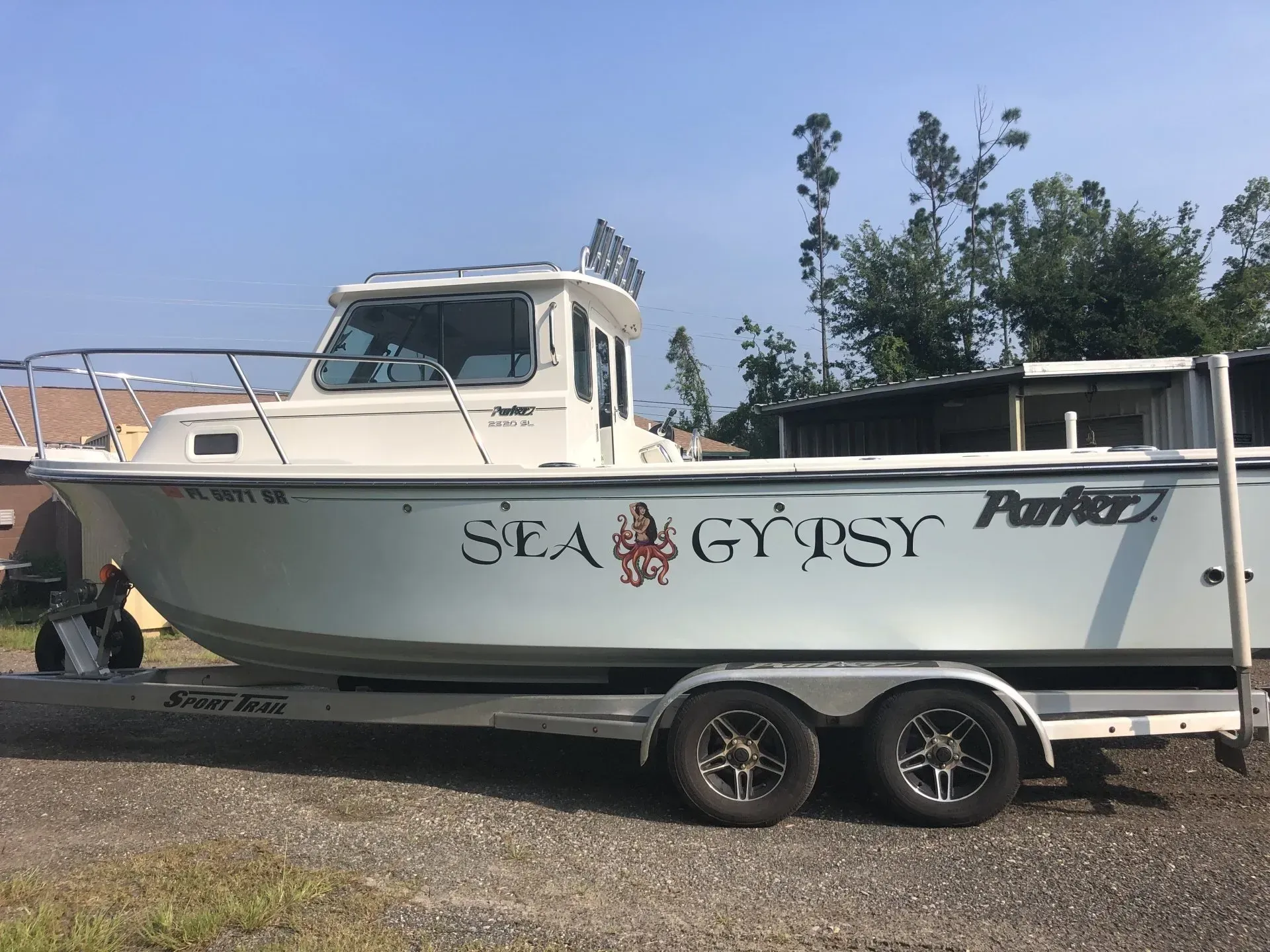 A boat on a trailer that says sea gypsy on the side
