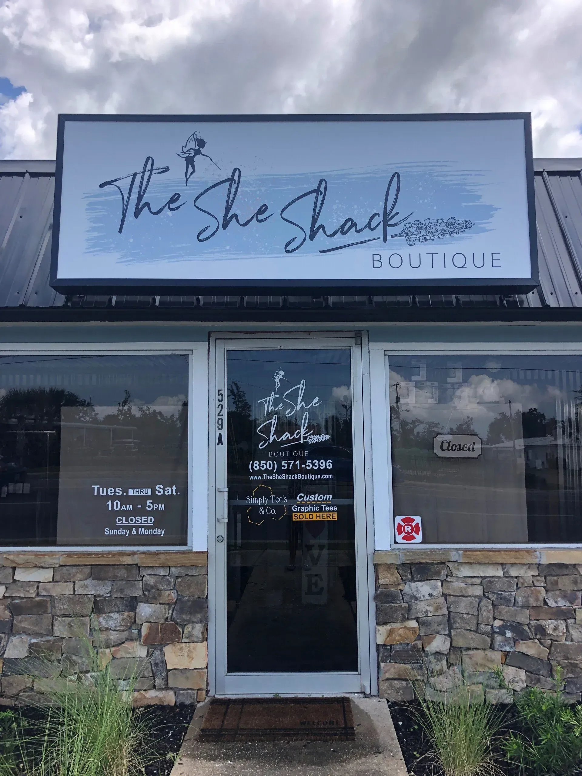 The front of the she shack boutique with a sign above the door.
