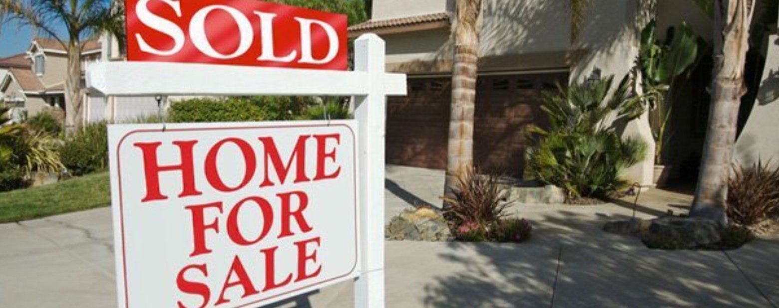 A sold home for sale sign is in front of a house.