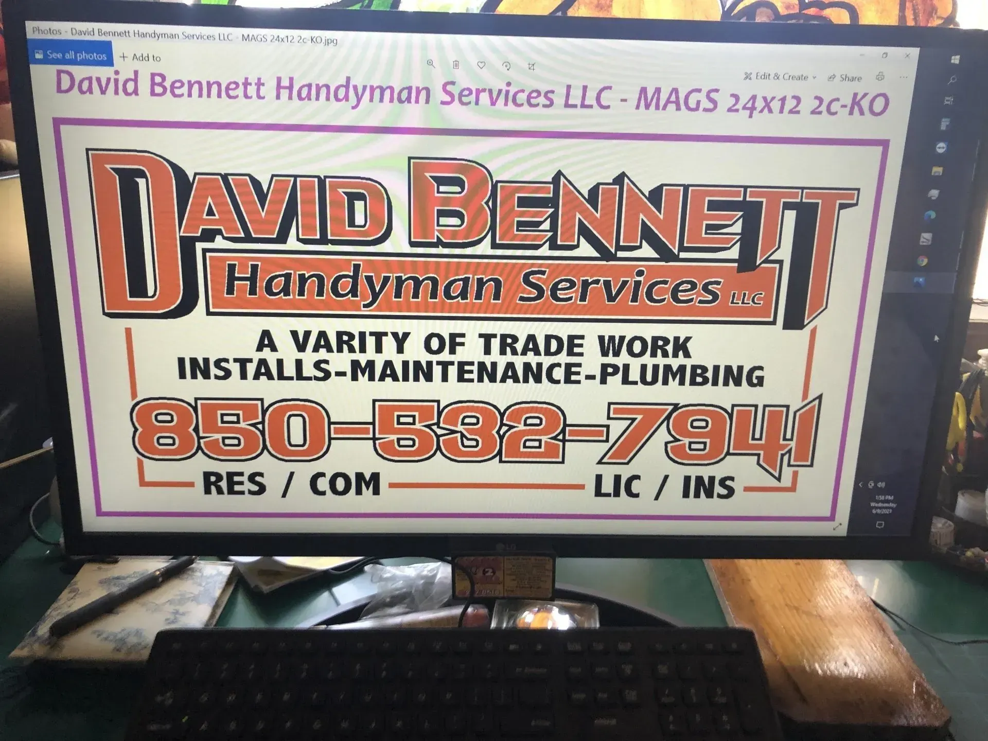 A computer monitor displays a sign for david bennett handyman services