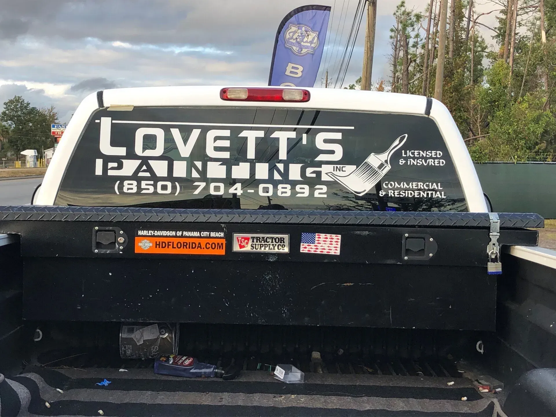A truck with a sign on the back that says lovett 's painting