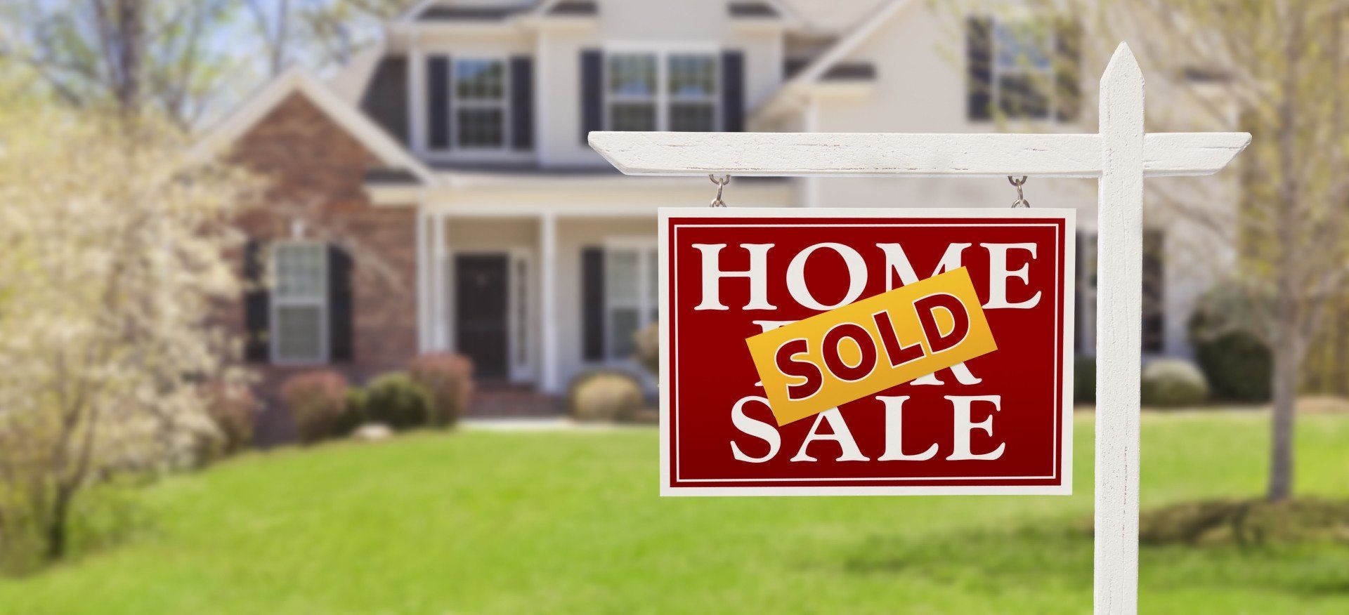 A home for sale sign in front of a house