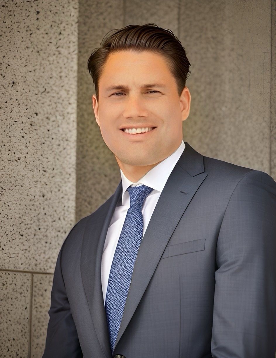 A man in a suit and tie is smiling for the camera