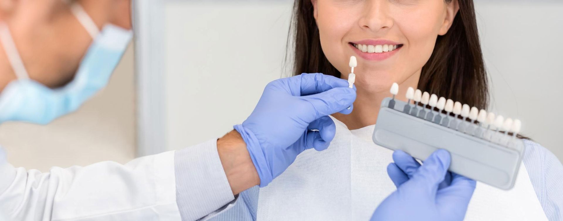 A dentist is examining a woman 's teeth in a dental office.