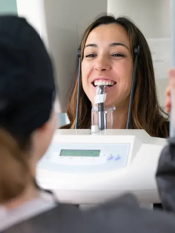 A woman is getting an x-ray of her teeth in a dental office.