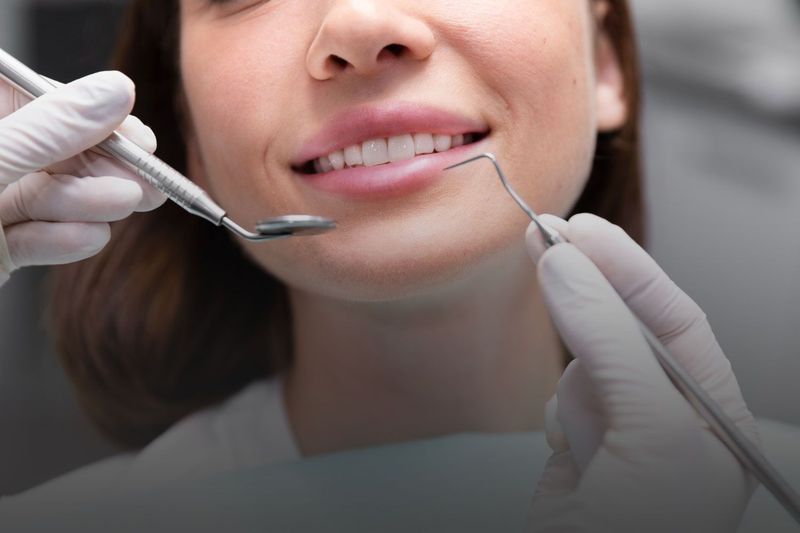 A woman is getting her teeth examined by a dentist.