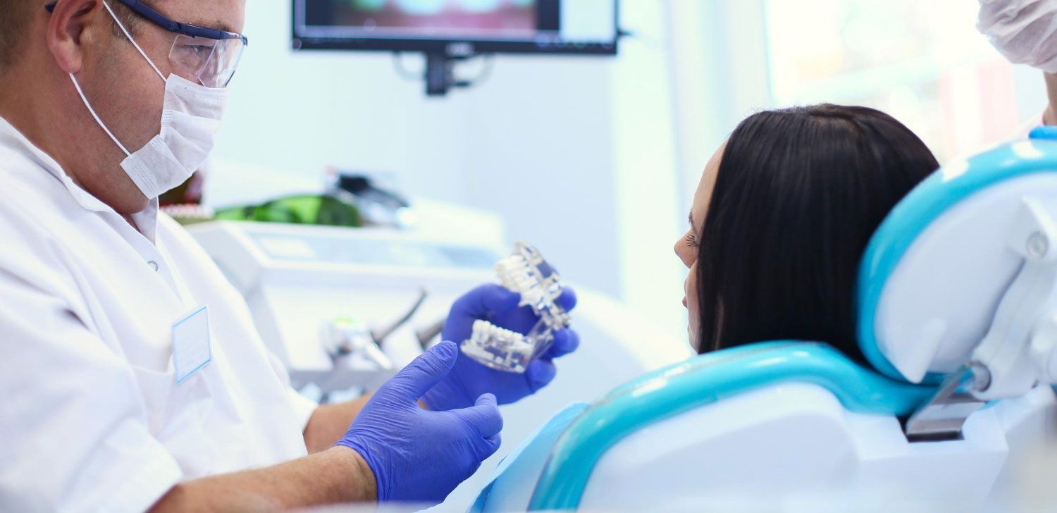A dentist is examining a patient 's teeth in a dental office.