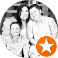 A black and white photo of a family sitting next to each other in a circle with an orange star.