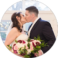 A bride and groom kissing on their wedding day in a circle.