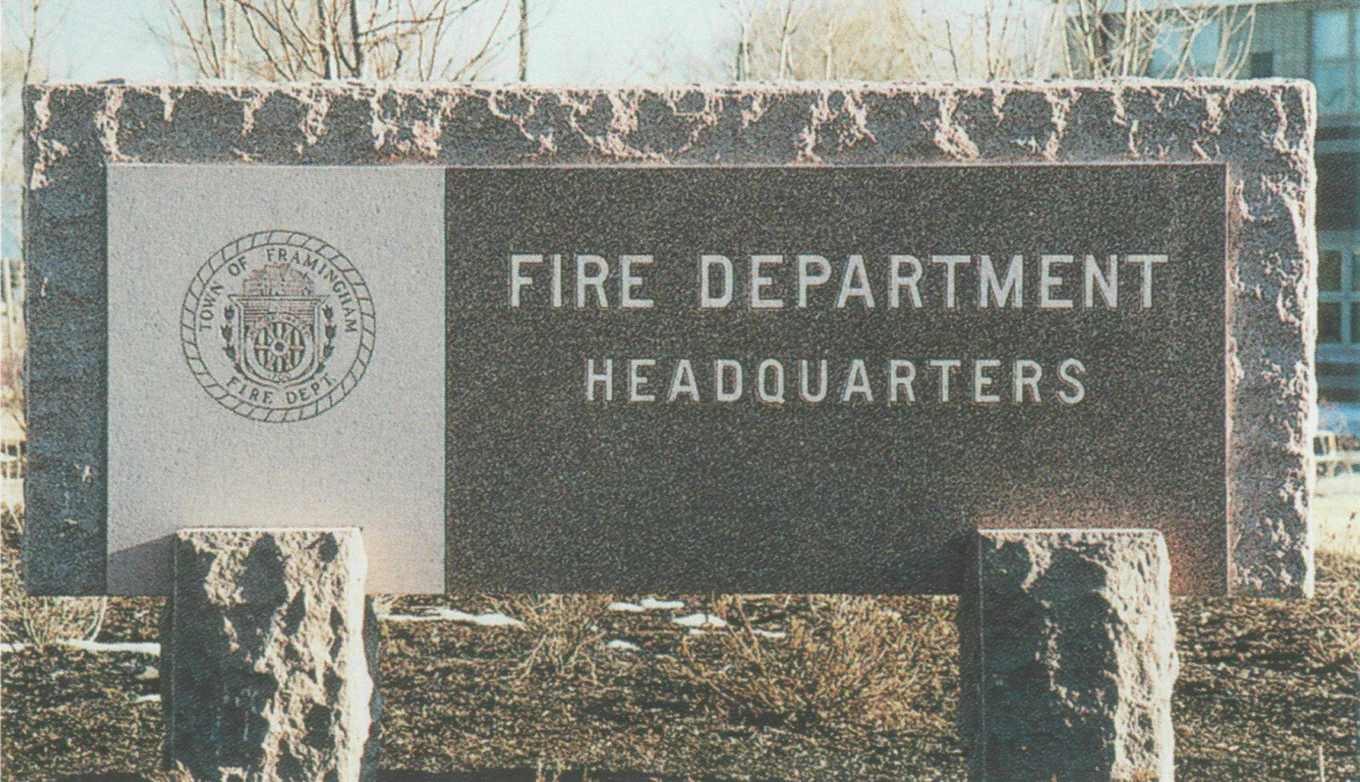 Stone sign reading Fire Department Headquarters in front of a building.