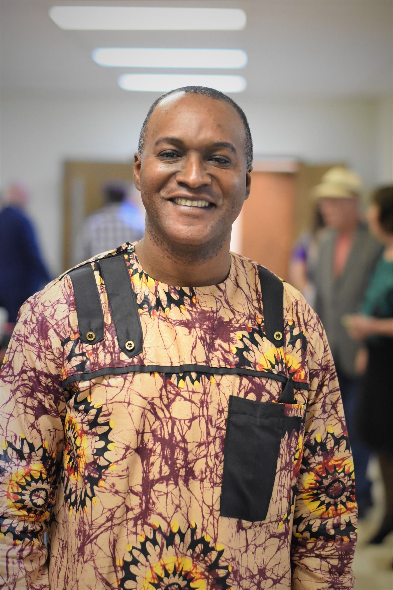 A man in a colorful shirt is smiling for the camera.