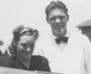 A man and a woman are standing next to each other in a black and white photo.