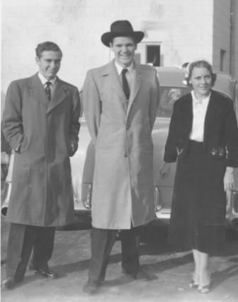 A black and white photo of three people standing next to each other