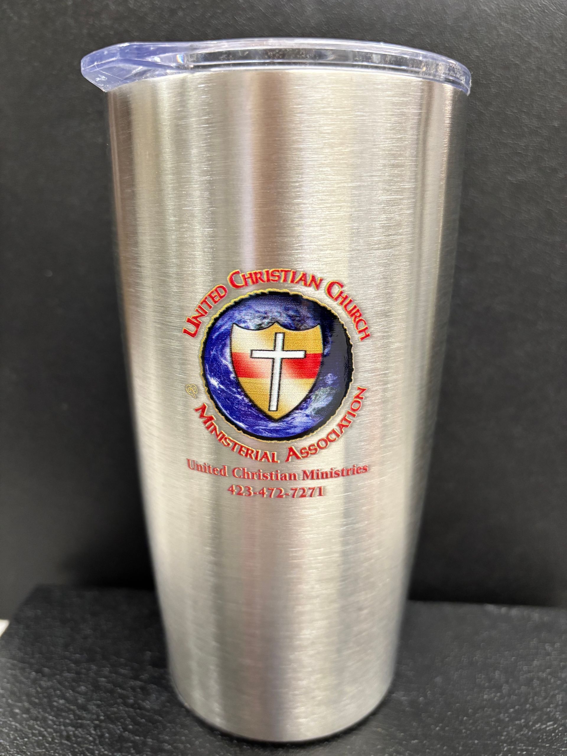 A stainless steel tumbler with a cross and shield on it.