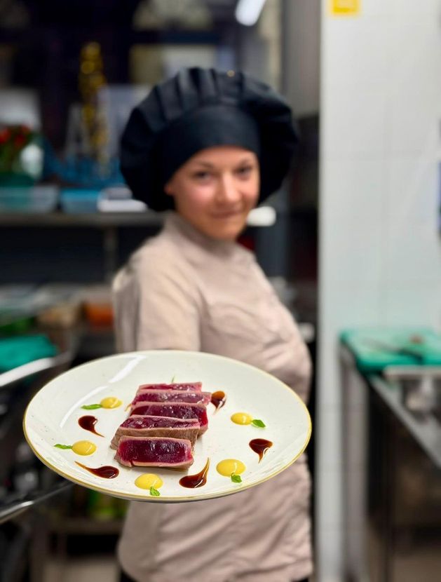 Apparecchiatura della tavola con piatti, bicchieri, posate e tovaglioli con stampe di pesci blu e verdi.