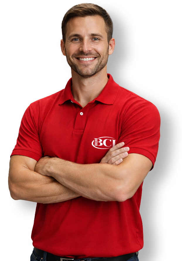 Smiling man in red polo shirt with arms crossed on a white background