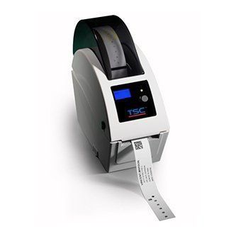 Compact gray label printer printing a barcode label with a blue display and black top cover