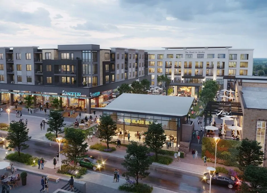 Modern apartment complex with a lively courtyard, shops, trees, and pedestrians at dusk