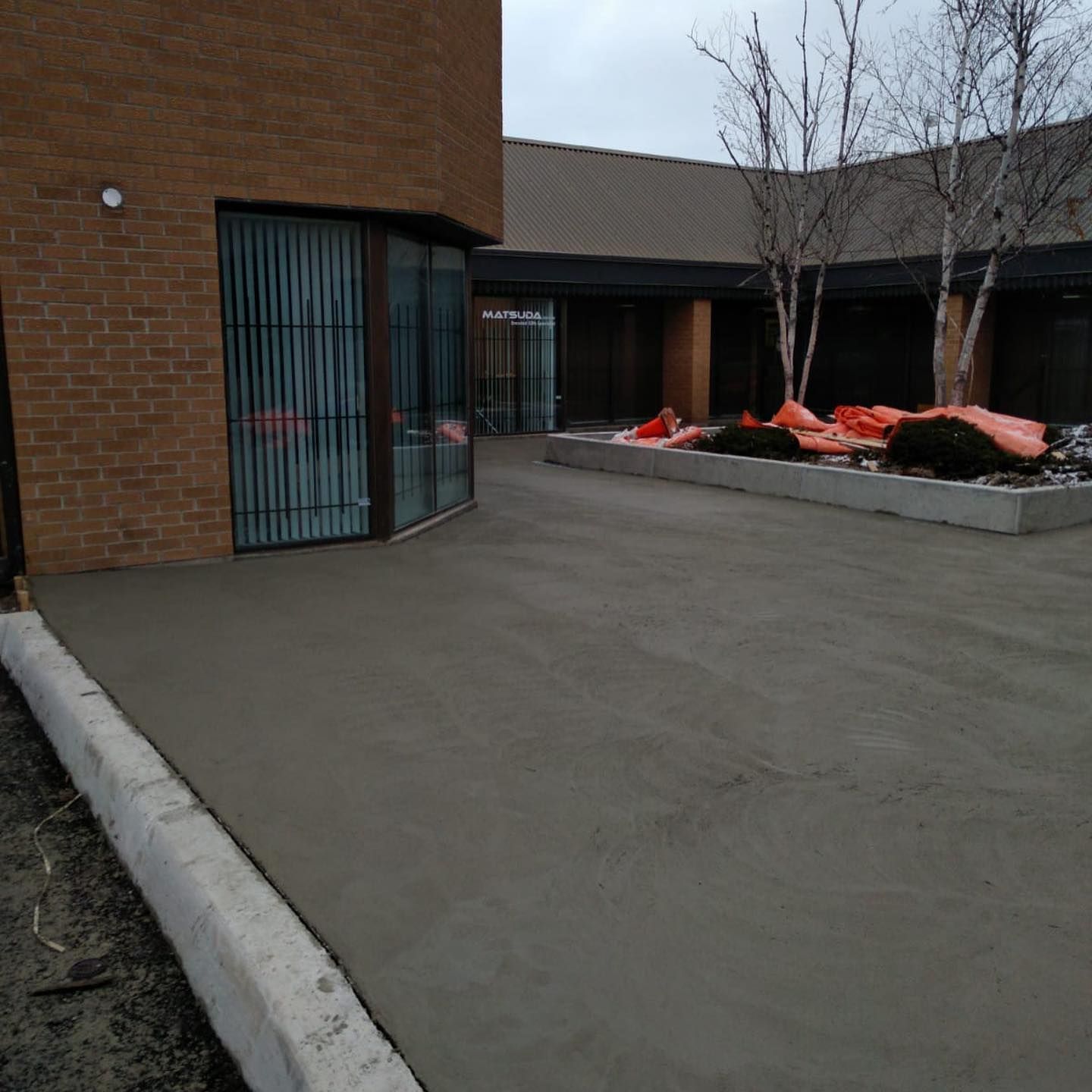 A brick building with a concrete driveway in front of it