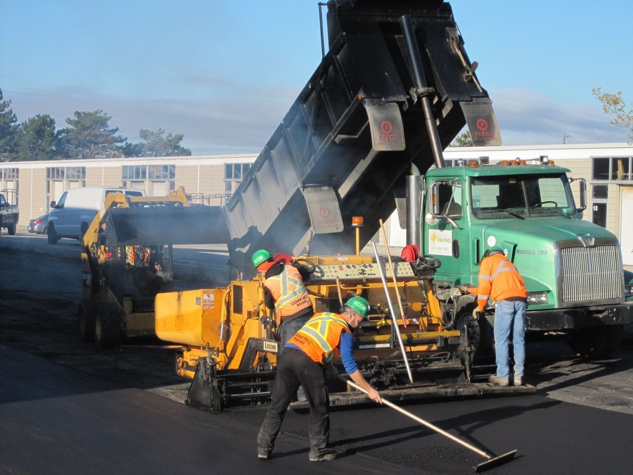 A group of construction workers are working on a road