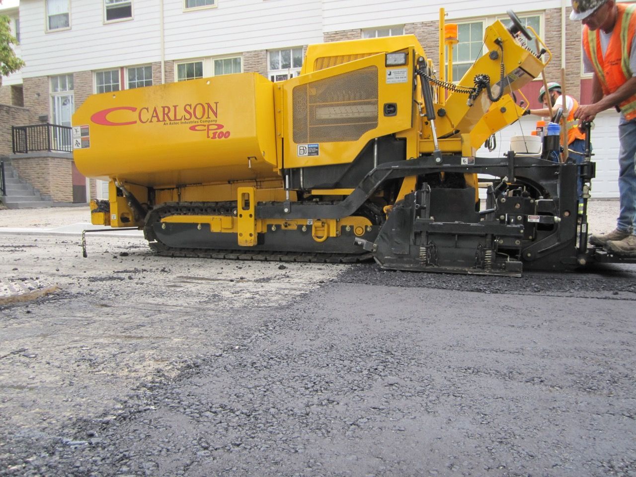 A carlson machine is being used to spread asphalt