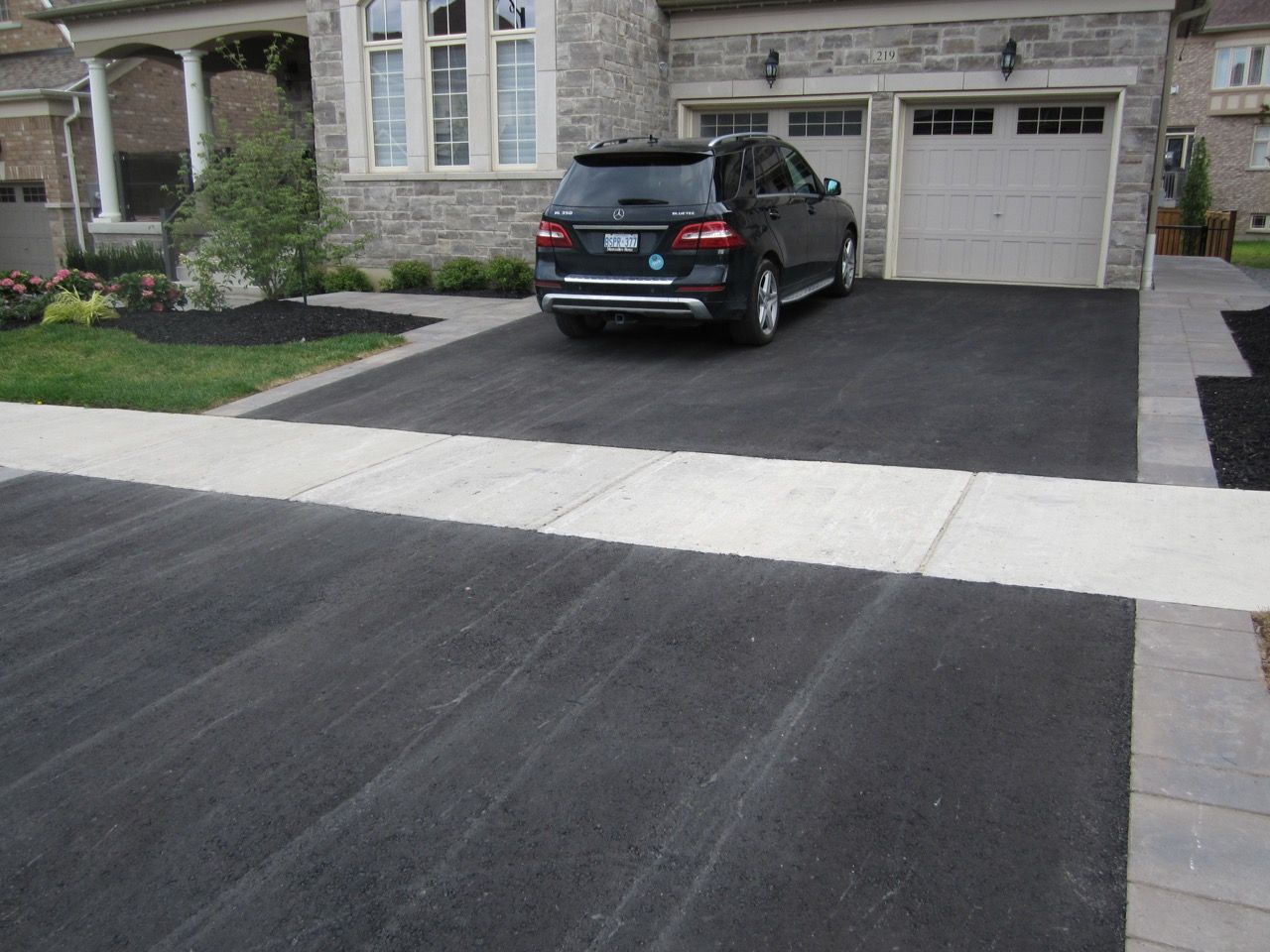 A black suv is parked in the driveway of a house