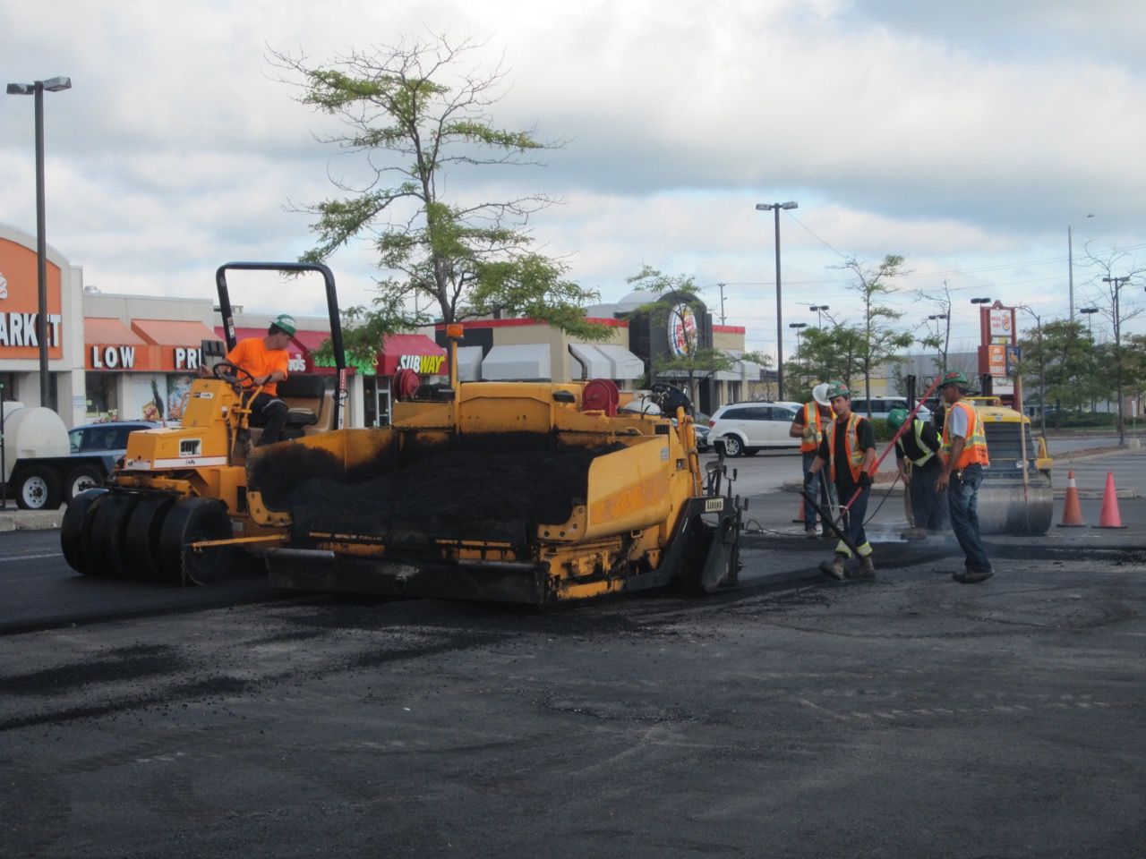 A group of construction workers are working on a parking lot