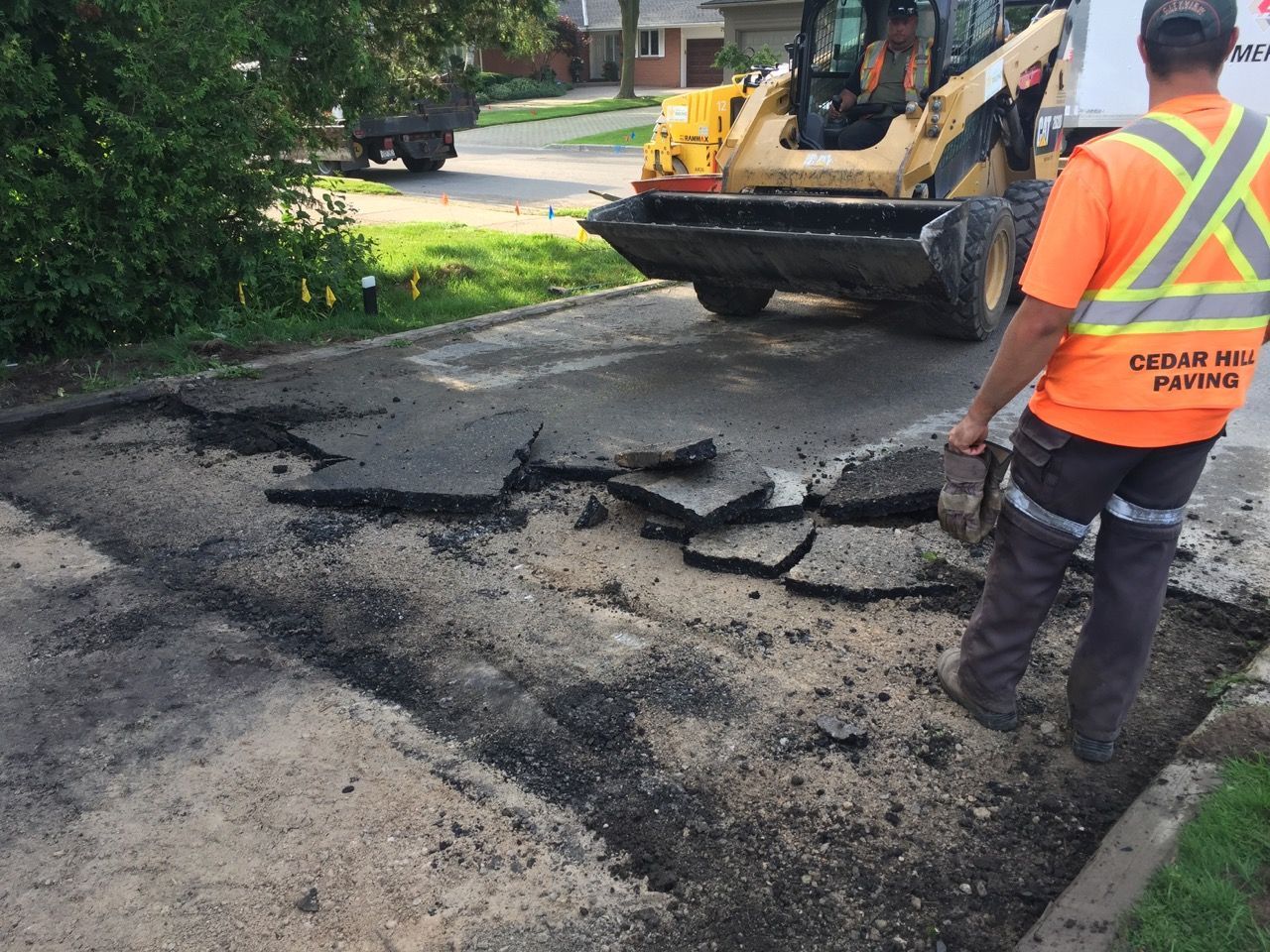A man wearing an orange vest that says cedar hill paving