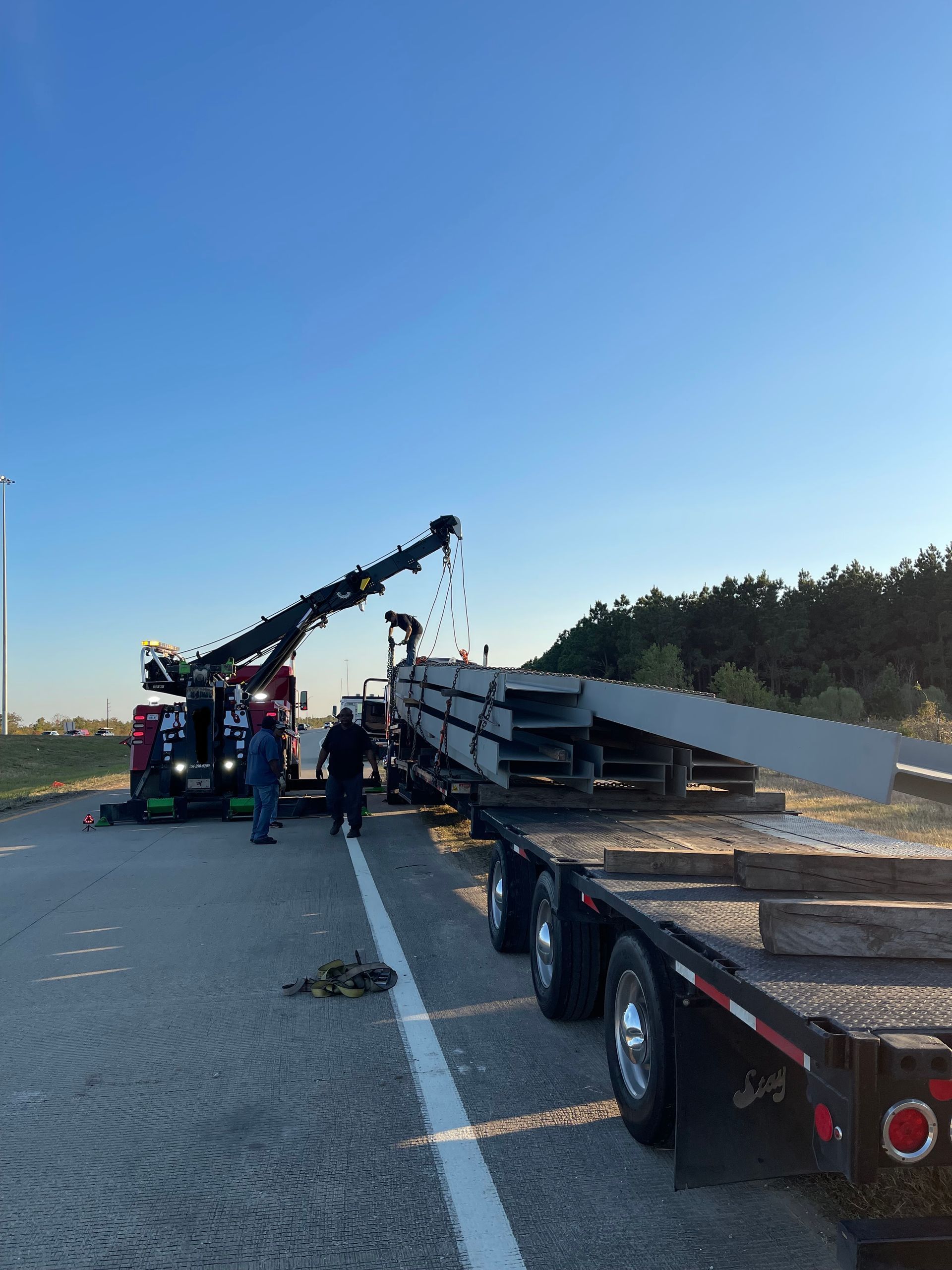 A tow truck is lifting a plane on a trailer