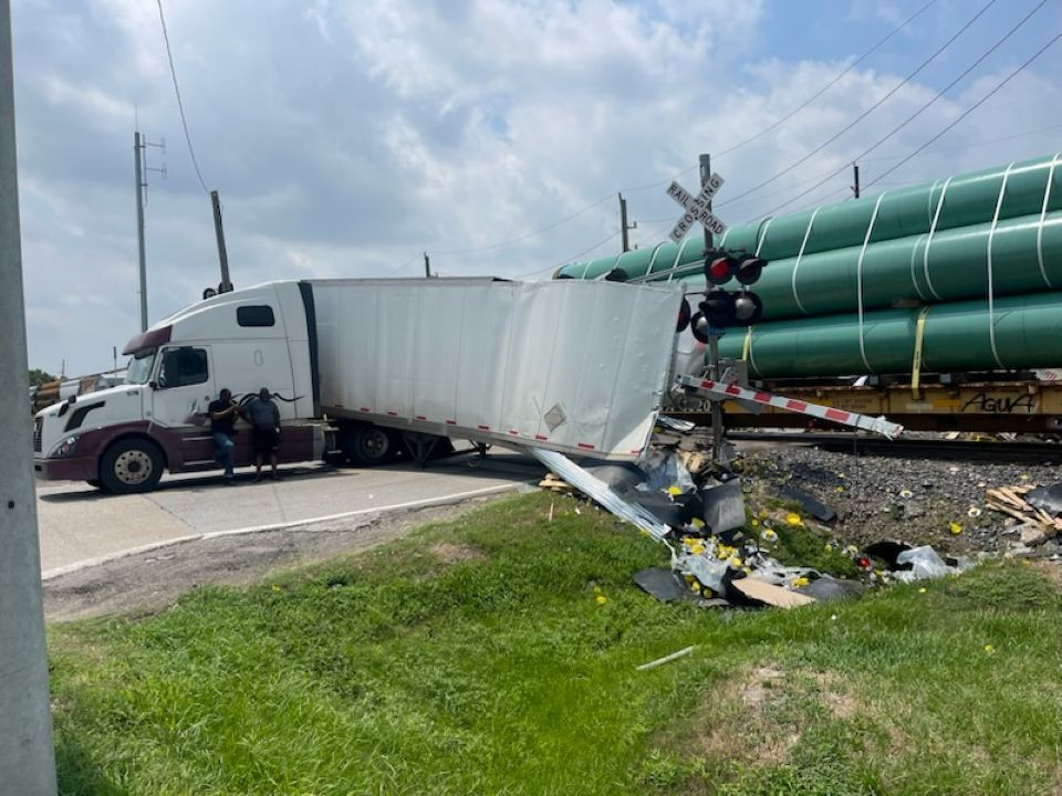 A semi truck has crashed into a train at a railroad crossing.