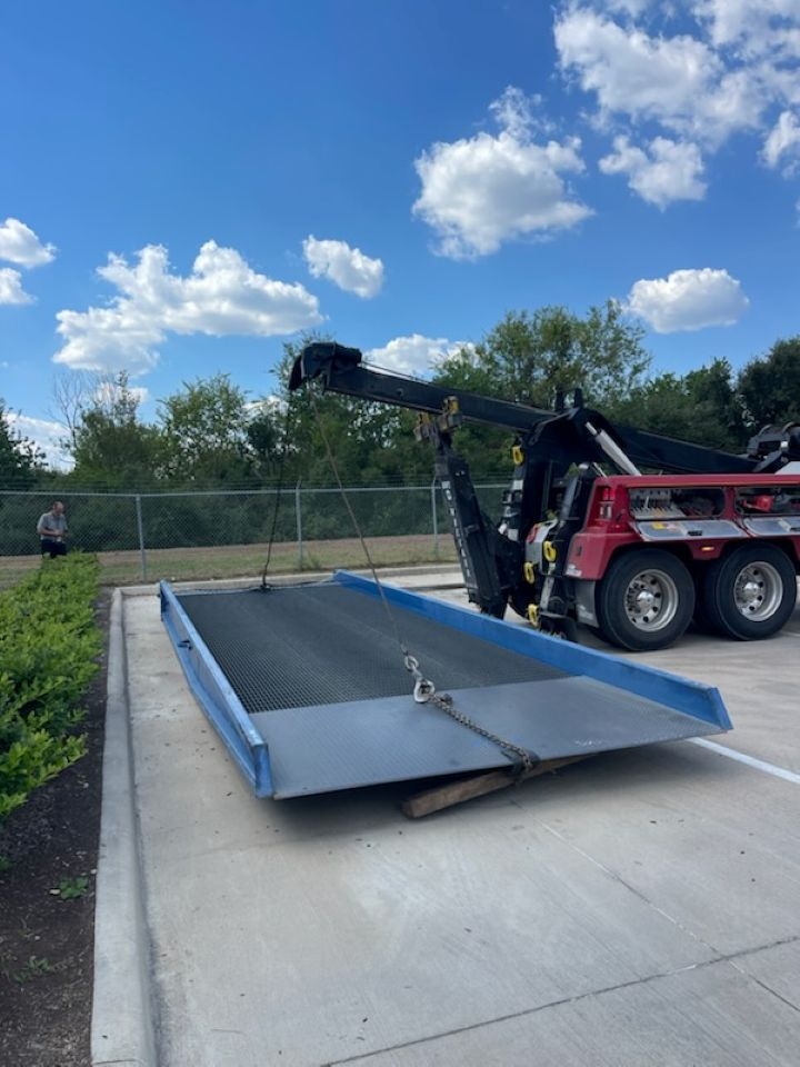 A tow truck with a crane attached to it is parked in a parking lot