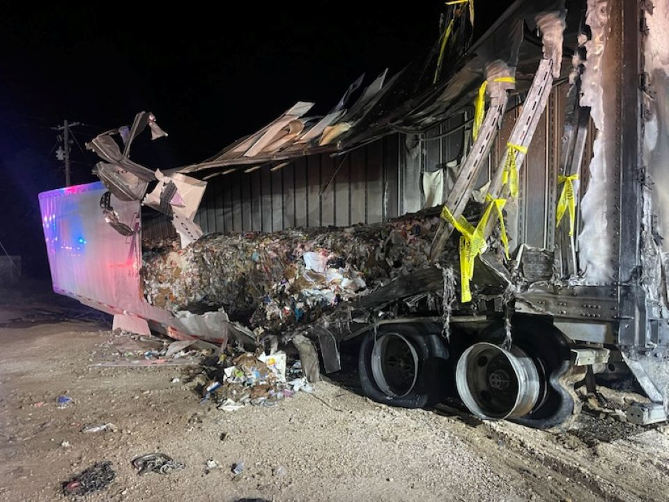 A semi truck has crashed into a building at night.