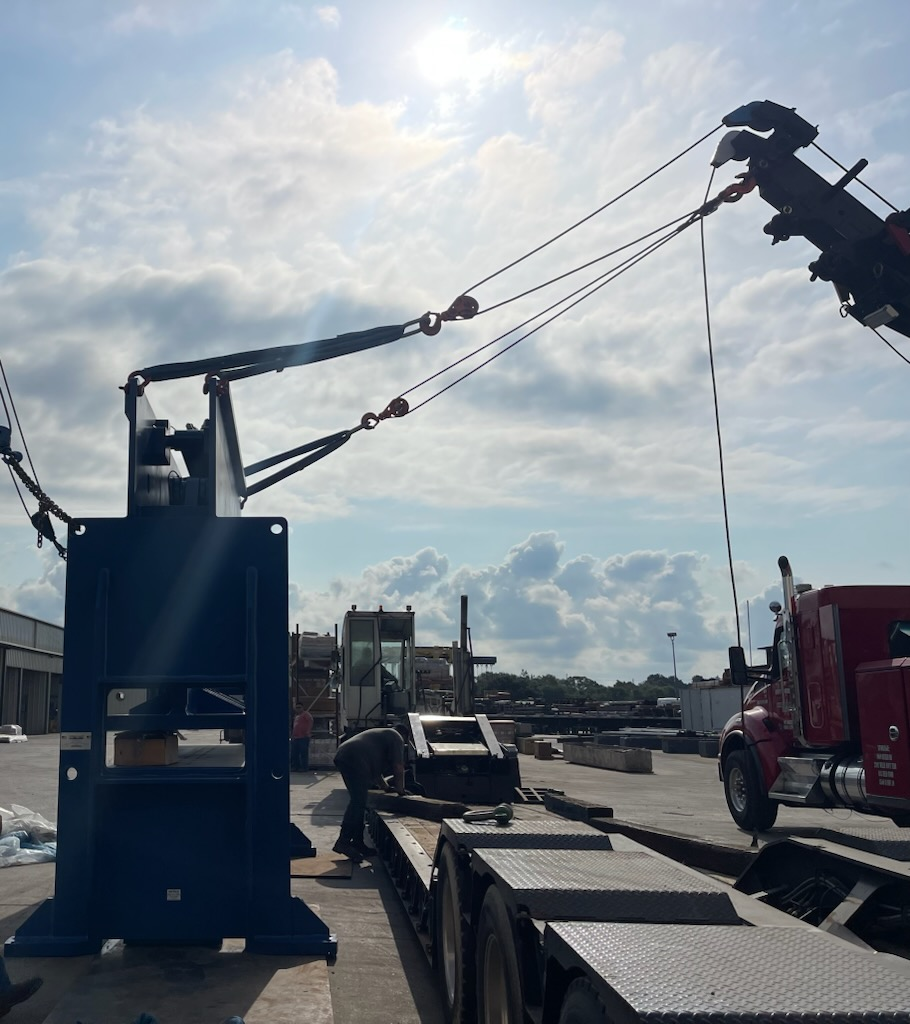 A truck is being towed by a crane in a parking lot