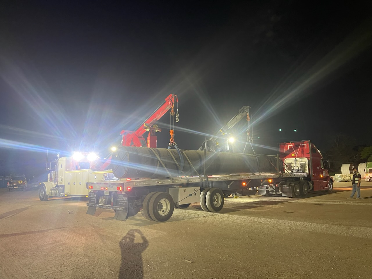 A truck is being towed by a tow truck at night.